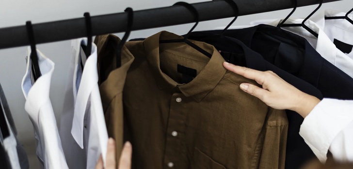 Persona mirando un perchero de ropa La confianza del consumidor sube en enero pero continua por debajo de los cien puntos