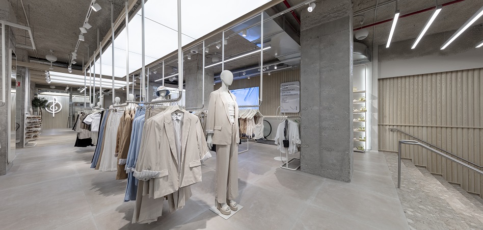 Zara vuelve a dar otra vuelta a su retail. La cadena de Inditex ha abierto hoy un nuevo establecimiento en la Plaza de España de Madrid, donde explora el equilibrio entre la conveniencia del modelo Amazon (entrar, comprar y salir sin hablar con nadie) y la asistencia del comercio tradicional.  El nuevo establecimiento de Zara en los bajos del hotel Riu es el mayor de la cadena, con una superficie total de 7.700 metros cuadrados, de los cuales 3.800 metro son de superficie comercial.  El flagship introduce un nuevo concepto que pronto se implantará también en las tiendas de Dubái y Ginza, en Tokio. En él se busca combinar “el reflejo de la imagen y moda de la marca con las herramientas más novedosas para la experiencia integrada”, según apuntan desde el grupo.        Zara ha introducido servicios como el Pay&Go y ‘showrooms’ para algunas colecciones     Entre esas nuevas herramientas se incluyen la compra a través de la aplicación, sin pasar por caja, códigos QR para acceder a los servicios de la tienda sin necesidad de descargarse la aplicación o sistemas para reservar probadores.  La principal novedad de la tienda consiste en la posibilidad de pagar un artículo de la tienda a través de la aplicación, para después desalarmarlo en uno de los diferentes puntos del establecimiento. El objetivo es evitar que el cliente desista de la compra cuando, por ejemplo, hay largas colas en las cajas.  Otro punto de fricción que el grupo busca solventar con tecnología es la espera para probadores. El cliente puede reservar cita (un sistema disponible hasta ahora a través de la aplicación, con el modo Tienda) y será avisado mediante un sonido cuando esté disponible.  Además, el establecimiento cuenta con un espacio para realizar devoluciones de pedidos online a través de un buzón, así como el sistema de recogida automatizada de pedidos que existe ya en otras tiendas. Junto a estos espacios, se han instalado buzones para reciclar las cajas de los pedidos o entregar prendas usadas para su reciclaje o reutilización.        FOTO  El establecimiento cuenta con espacio destinados a las colecciones de íntimo (que hasta ahora sólo se vendía online), calzado o deporte        Junto con estos servicios para que el cliente pueda realizar la compra de forma más autónoma se encuentran otros más enfocados a la venta asistida, como los showrooms dedicados a calzado, accesorios, íntimo (que hasta ahora se vendía sólo online) o a la colección deportiva.  En estos espacios, están en exposición solamente una talla por producto, y cuentan con dos dependientes para asistir al cliente y pequeños almacenes adyacentes para realizar las reposiciones de forma ágil.  De esta forma, el producto gana más protagonismo. Eso es lo que se persigue también en la propia distribución de la tienda, organizada de forma concéntrica con amplios espacios. El interiorismo, desarrollado por el estudio de arquitectura de Zara, combina una estética industrial en algunas zonas con áreas más cálidas con mesas, maderas y alfombras.  Entre las novedades se encuentra también un área dedicada a la línea de belleza que incorpora un nuevo concepto, una nueva línea de bases de maquillaje y un servicio de maquillaje para el que ya no hay cita disponible.  El Zara Plaza de España también cuenta con algunos de los sistemas de ecoeficiencia medioambiental más avanzados y opta al sello Breeam, certificado europeo de construcción sostenible. Las medidas adoptadas en esta apertura se reflejan, por ejemplo, en la eficiencia de los sistemas de calefacción y refrigeración, iluminación LED para un mayor ahorro de energía, y utilización de materiales más respetuosos con el medioambiente, entre otras.     FOTO  Stradivarius también ha estrenado hoy un nuevo concepto de tienda en el Edificio España     Stradivarius también ha abierto hoy su tienda en Plaza España con un nuevo concepto de tienda, Wave. El establecimiento cuenta con una superficie total de 1.240 metros cuadrados distribuidos en dos plantas y está ubicado en los bajos del remodelado Edificio España de Gran Vía, 84.  Wave da nombre a una nueva decoración con formas y acabados en el mobiliario curvos y redondeados. “Las líneas cuadradas y los vértices se convierten en líneas curvas con sensación de movimiento que hacen referencia al ondeado de las olas del mar”, explica la cadena.  La tienda cuenta con una zona de caja física y de cajas de autocobro, acceso a wifi gratis y una zona online para la recogida de pedidos realizados a través de la web y app.  También incorpora el Modo Tienda, a través del cual el cliente puede navegar, en web y app, sobre la disponibilidad de producto en tienda en tiempo real, realizar un pedido y recogerlo en ese mismo punto en una hora.  Para acercar al cliente estos servicios, se ha colocado además una gran pantalla en el interior de la tienda, a través de la cual se comunicarán colecciones, novedades y otros servicios que ofrece la marca.  Inditex, presidida desde la semana pasada por Marta Ortega, es el mayor grupo de distribución de moda del mundo. El grupo cerró 2021 con un crecimiento interanual de las ventas del 36%, hasta 27.716 millones de euros, un 2% menos que en 2019. El beneficio tiene todavía más terreno que recorrer: aunque se casi triplicó respecto a 2020, está aún un 11% por debajo de 2019